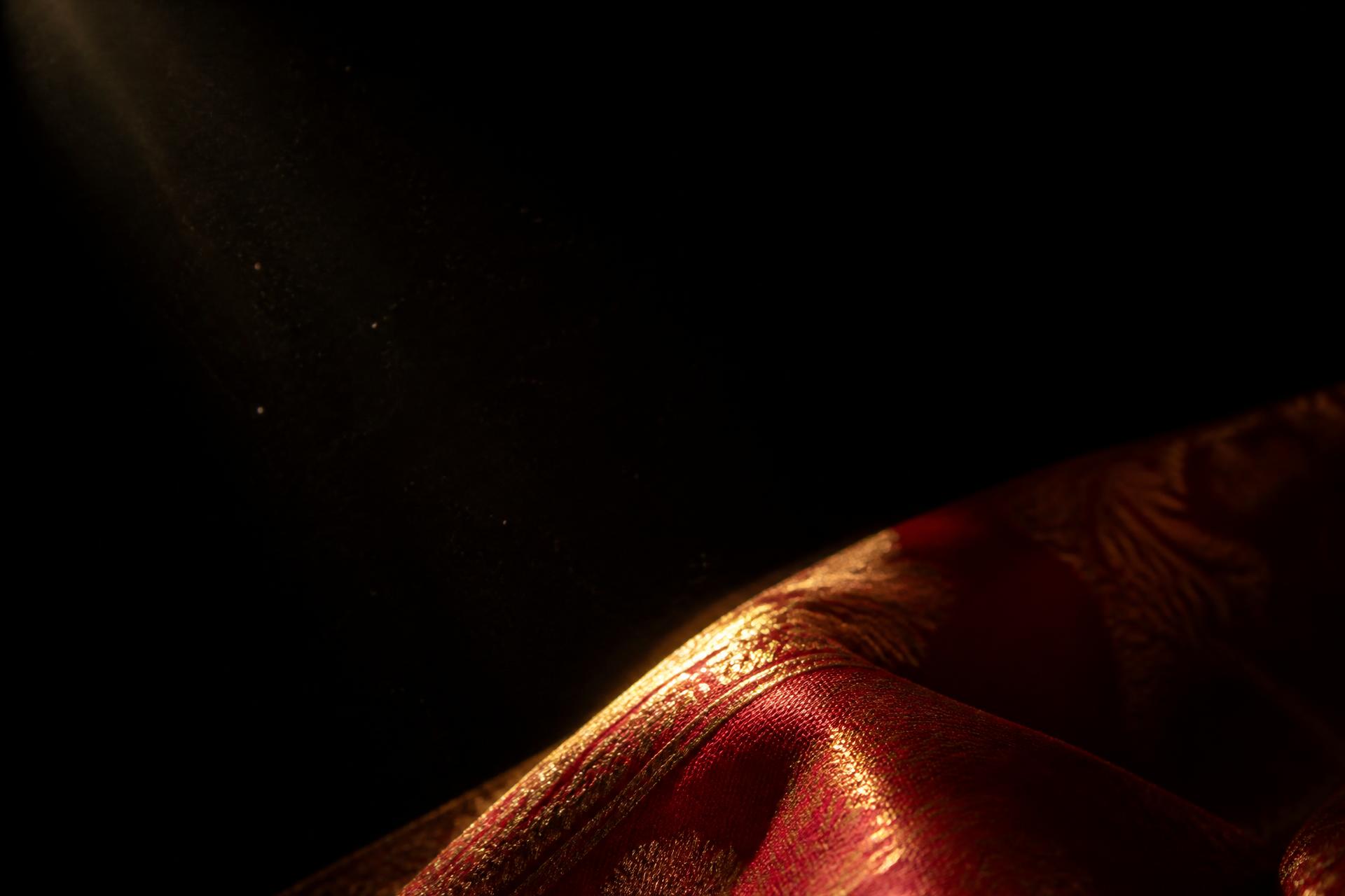 A fold of silk emerging from darkness